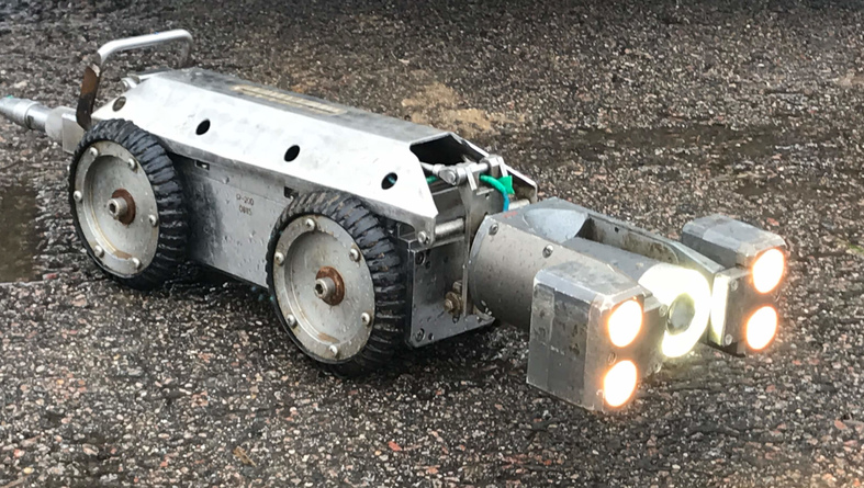 Робот для телеинспекции трубопроводов «ТАРИС Р200-5М» на колесах диаметром 150мм. Помимо освещения «холодного» спектра на видеокамере, на роботе установлены дополнительные галогеновые светильники «тёплого» спектра.